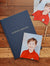 Navy album labeled 'School Photos' with a school portrait photo on a wooden surface.